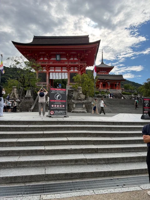 朝の清水寺仁王門前の石段と観光客。奥に三重塔