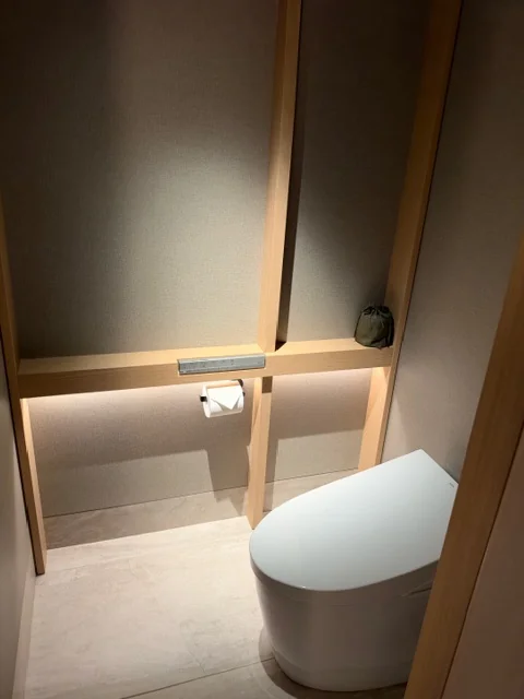 木の格子と間接照明で設えられた客室のトイレ